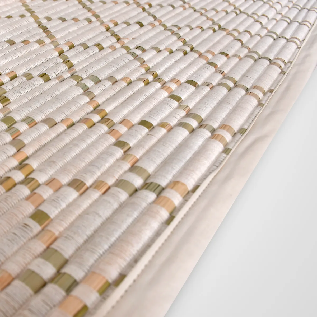 Close-up of the Sambu Diamond mat showing sambhu grass wrapped in white cotton with green and peach bands and a cloth-bound edge